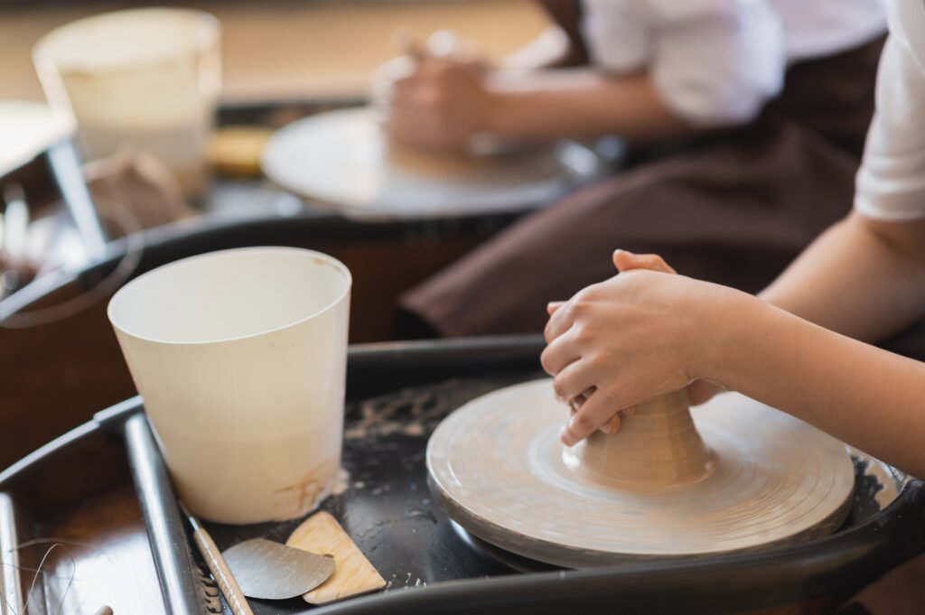 two-female-ceramic-artists-in-apron-using-clay-mat-2023-11-27-05-01-37-utc